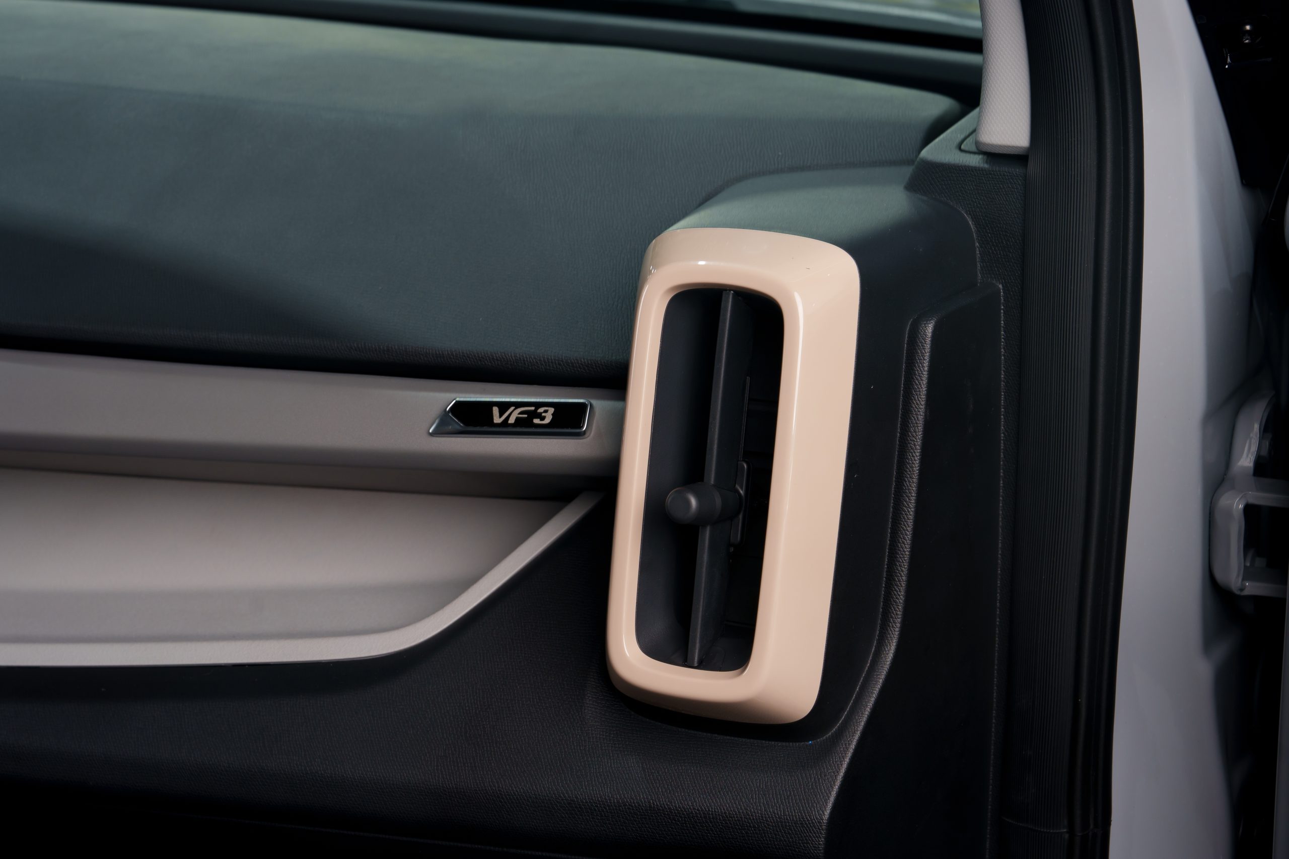 Cửa gió VinFast VF3 — khe gió viền beige và logo VF3, xe điện mini SUV